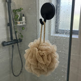 Gancio Wove nero su una parete doccia in vetro con una spugna beige