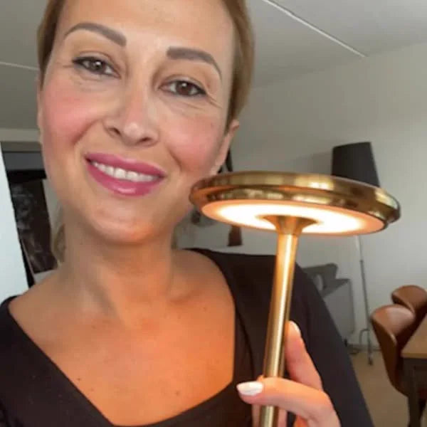 Cliente che tiene la lampada Copenhagen oro davanti a sé